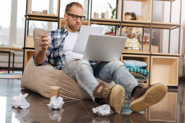 istock Hard working creative man holding crumpled ball of paper 657482336