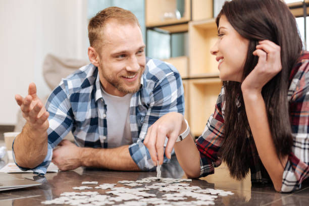 Cheerful attractive woman holding a jigsaw puzzle piece