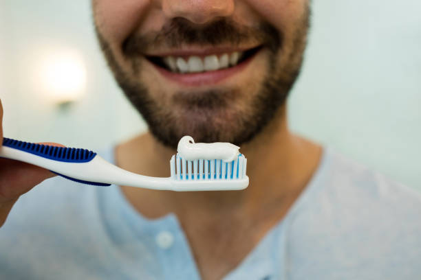 istock Close-up of happy young man holding toothbrush with toothpaste 657488746