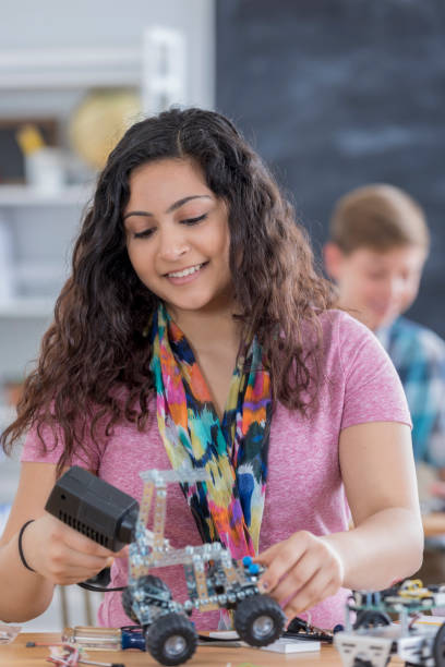 istock Beautiful high school girl builds robot in class 657489872