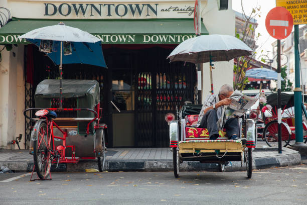 Rickshaw reading a newspaper in George Town, Penang stock photo