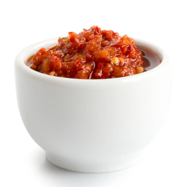 istock Red chopped chilli peppers in oil in ceramic white bowl isolated on white. 657499776