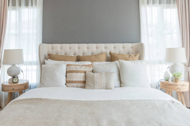 sypialnia w delikatnych jasnych kolorach. duże wygodne łóżko podwójne w eleganckiej klasycznej sypialni w domu. - indoors luxury domestic room house zdjęcia i obrazy z banku zdjęć