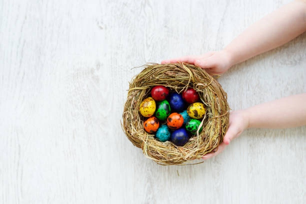 istock Child holding a nest with colored Easter eggs at home on Easter day 657517658