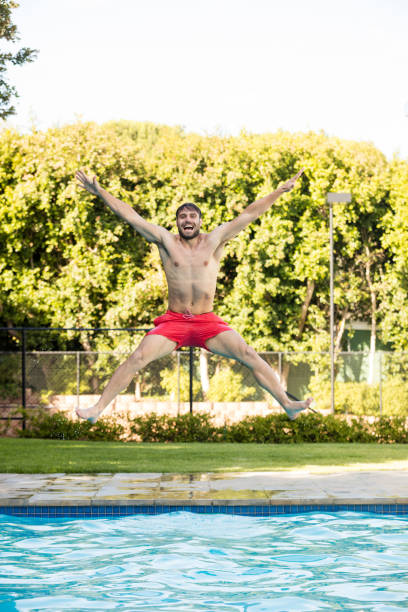istock Young man jumping in the pool 657532536