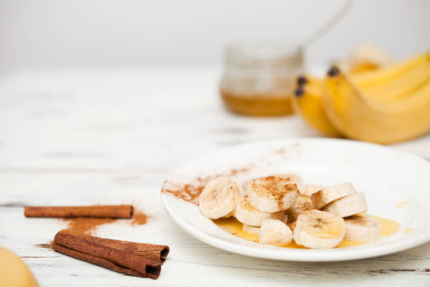 bunch of bananas and a cut banana on a plate.