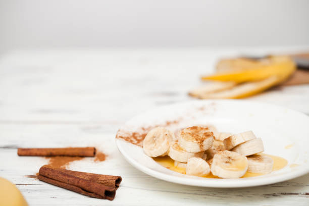 bunch of bananas and a cut banana on a plate.