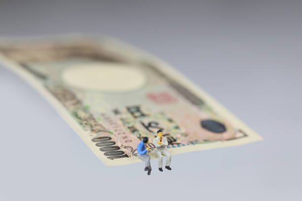 istock Miniature businessmen and 10000 Yen bills 657542420