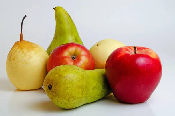 Apples and pears close-up on a light background.