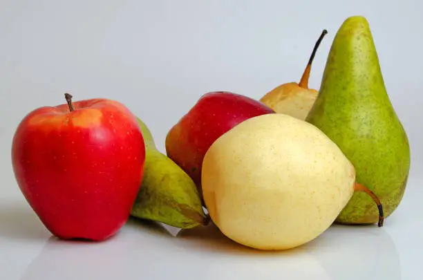 Apples and pears close-up on a gray background.