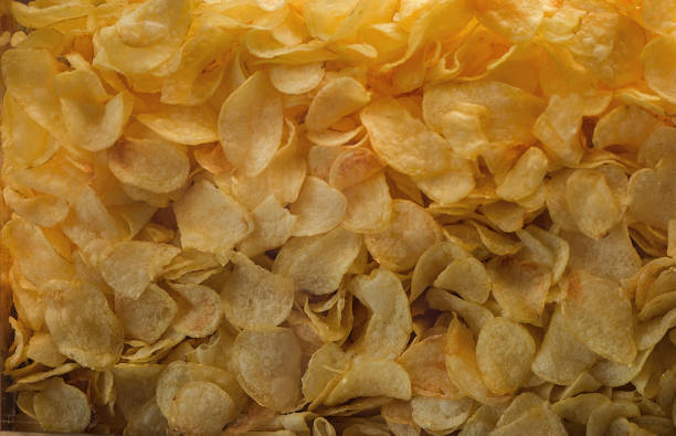 istock A lot of potatoes chips. Yellow salted potato chips as background. 657547522