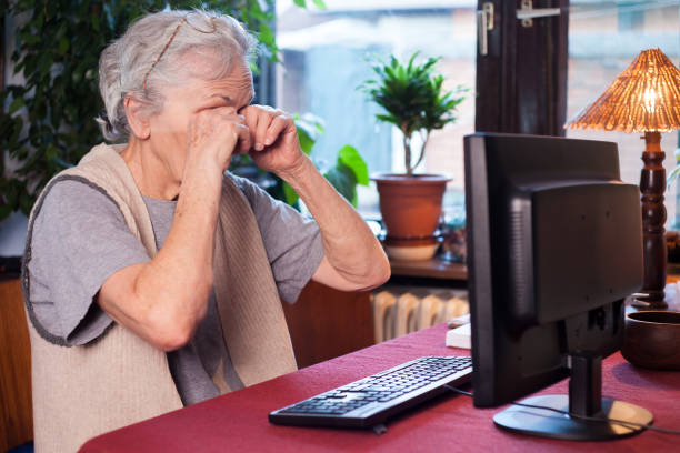 istock tired old woman sitting in front of the computer 657554302