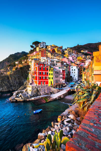 riomaggiore a paisagem da cidade, o cabo e o mar ao pôr do sol. cinque terre, ligúria, itália - cinqueterre - fotografias e filmes do acervo