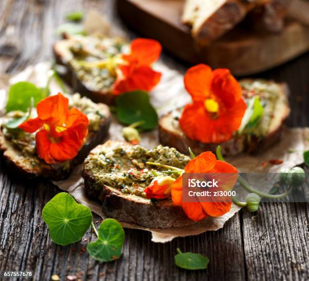 Sandwich With Herb Pesto And Edible Nasturtium Flowers Stock Photo - Download Image Now