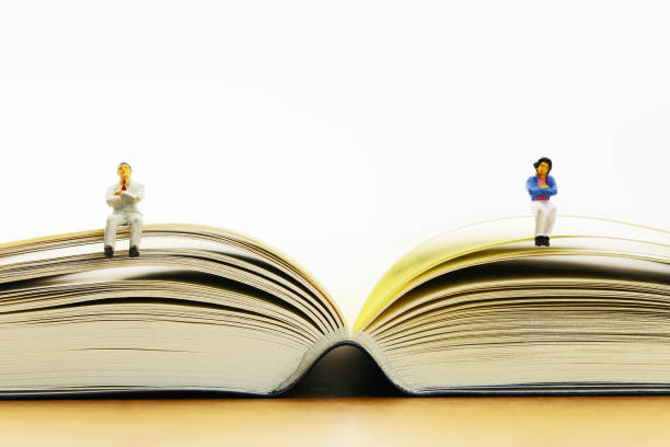 istock Men and women sit in an open book miniature 657558206