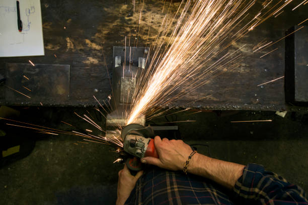 Locksmith whetting metal with flying sparks stock photo