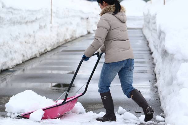 istock A Japanese woman shoveling snow 657564006