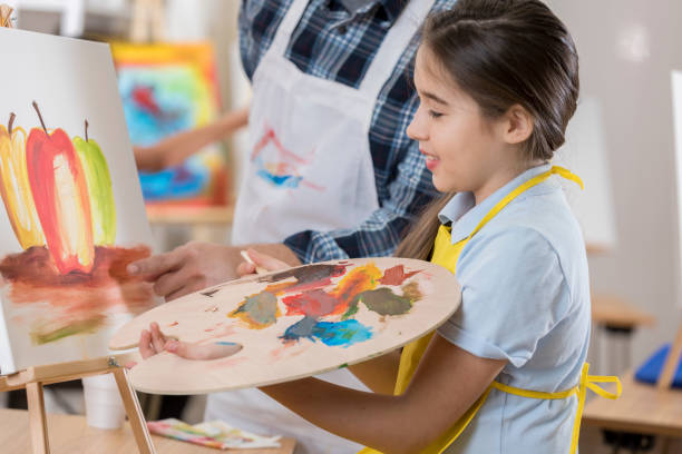 istock Cheerful girl paints in art class 657565338