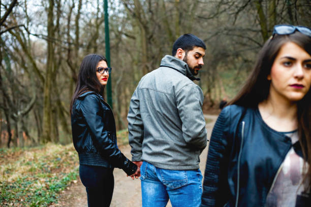 istock Man walking with his girlfriend and looking at another girl 657569274