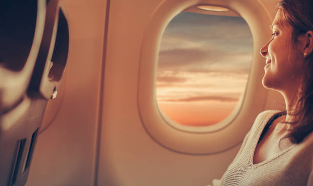 młoda kobieta podróżująca samolotem - airplane window looking through window indoors zdjęcia i obrazy z banku zdjęć