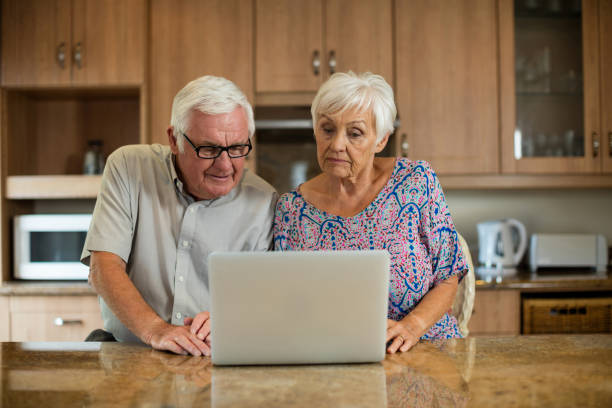 istock Senior couple using laptop in the kitchen 657571684