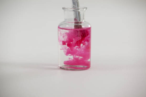 istock Paintbrush with pink paint dipped into a jar filled with water 657571972