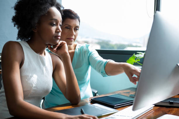 istock Female graphic designer pointing to desktop pc 657572316