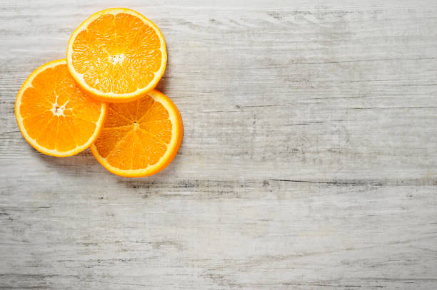 istock Slices of fresh oranges on white wood background 657572880