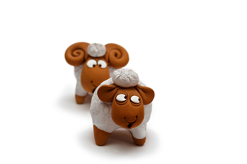 Two white and brown ceramic sheep figurine isolated on white background close up