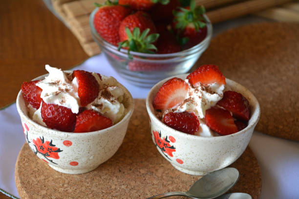 istock Chopped strawberries and whipped cream on a bowl on a wodden table. 657598946