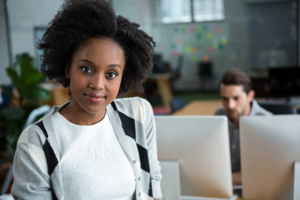 istock Happy woman standing in office 657599590