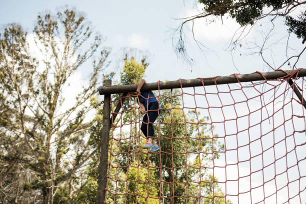 istock Fit woman climbing a net during obstacle course 657605762