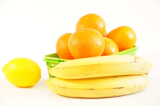 Ripe fruit isolated on white background. Bananas, tangerines, oranges, lemon, kiwi, apple on the table