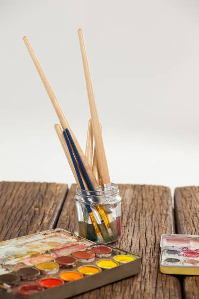 istock Paint brush in a jar filled with water and watercolors 657623896
