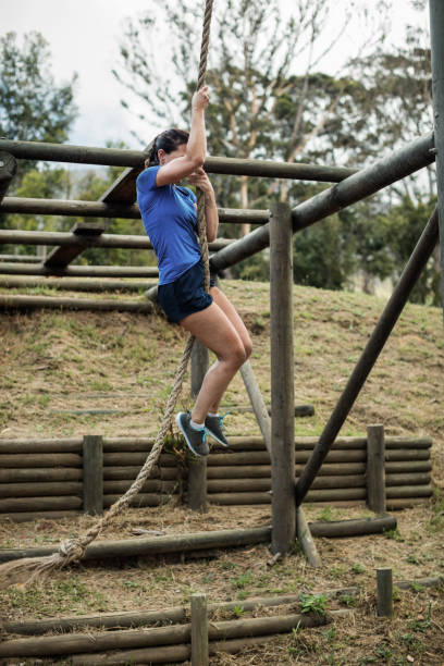 istock Fit woman climbing down the rope during obstacle course 657630212