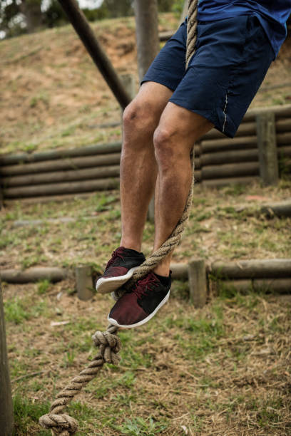 istock Low section of man climbing a rope during obstacle course 657630572