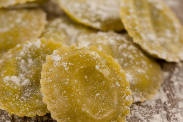 istock Round ravioli pasta dusted with floor on wooden background 657662336