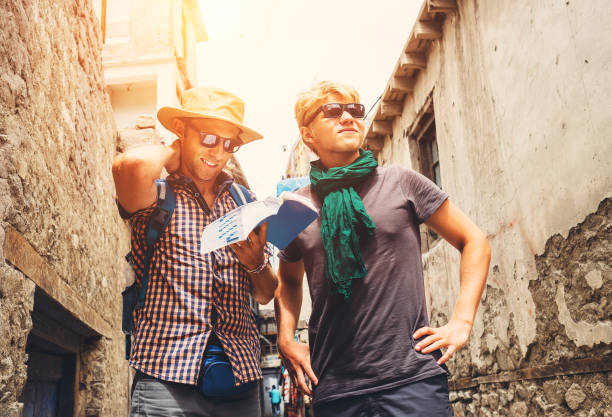 Two tourists try to navigate with guidebook on unknown asian street