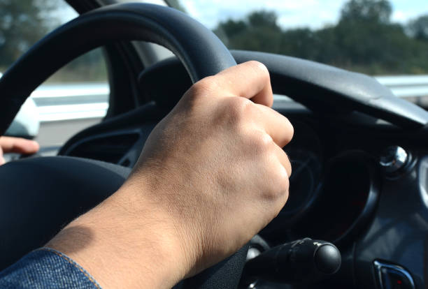 istock Right hand holding the wheel while driving on road 657663378