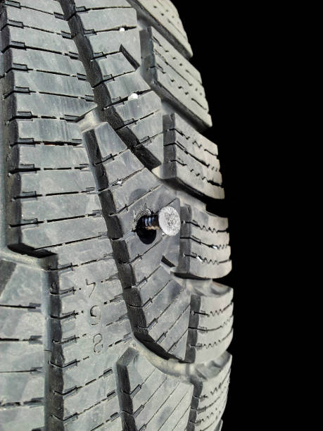 Screw into rubber tire isolated towards black stock photo