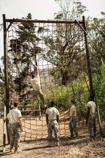 istock Military soldier climbing rope during obstacle course 657672570