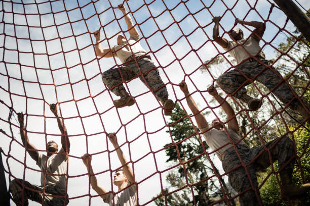 Military soldiers climbing rope during obstacle course Military soldiers climbing rope during obstacle course in boot camp military lifestyle stock pictures, royalty-free photos & images