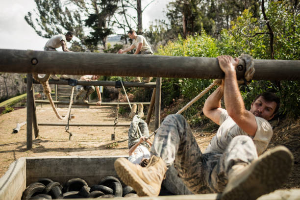 istock Young military soldiers practicing rope climbing during obstacle course 657681752