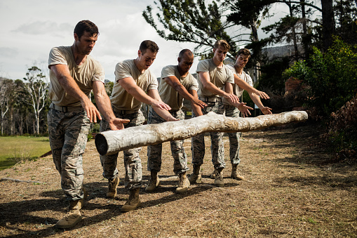 Soldiers dropping a tree log in boot camp