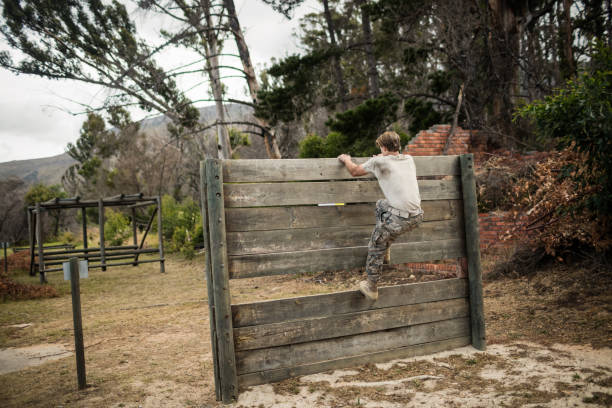 istock Soldier climbing wooden wall in boot camp 657688282