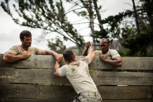 soldaten helfen holzwand erstbesteiger - military training camp stock-fotos und bilder