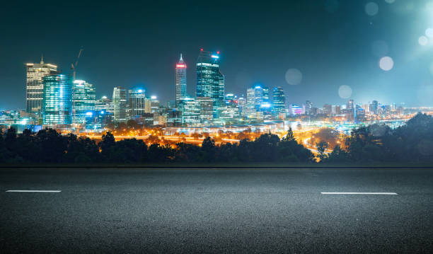 istock Empty asphalt road and cityscape skyline at night with light flare bokeh effect . 657688502