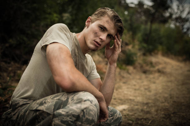 istock Tired soldier with hand on head sitting in boot camp 657688592