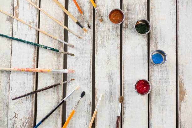istock Paintbrushes and watercolors arranged on wooden surface 657688914