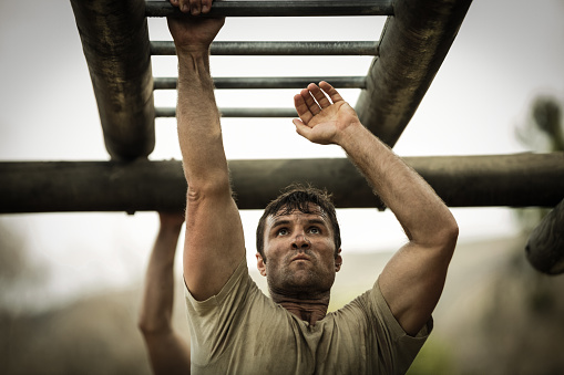 Soldier climbing monkey bars in boot camp